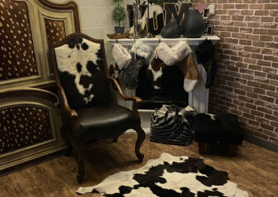 Animal hide upholstered chair and carpet together with decorated fireplace